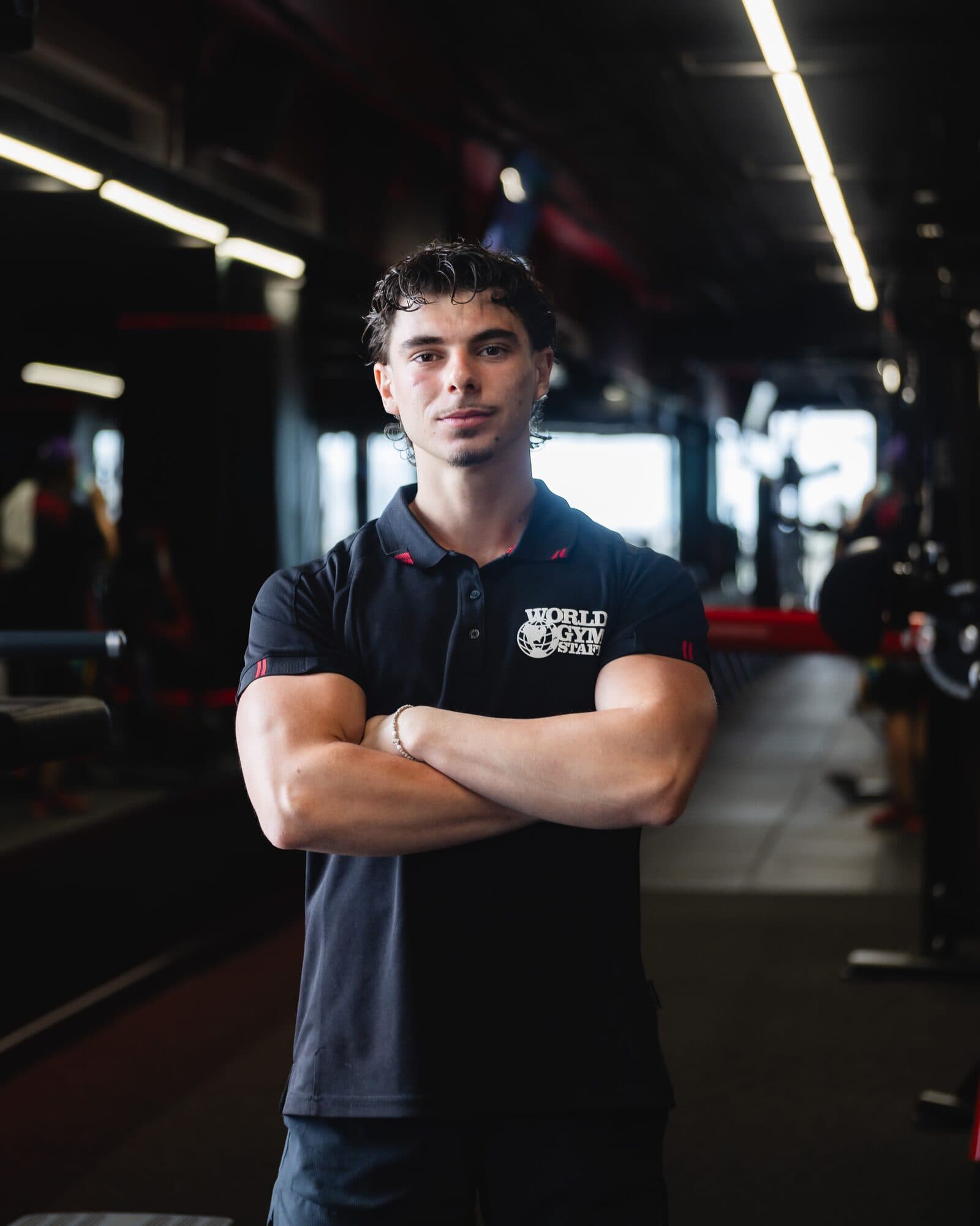 Coach Daniel Kovacs standing in the gym with arms crossed